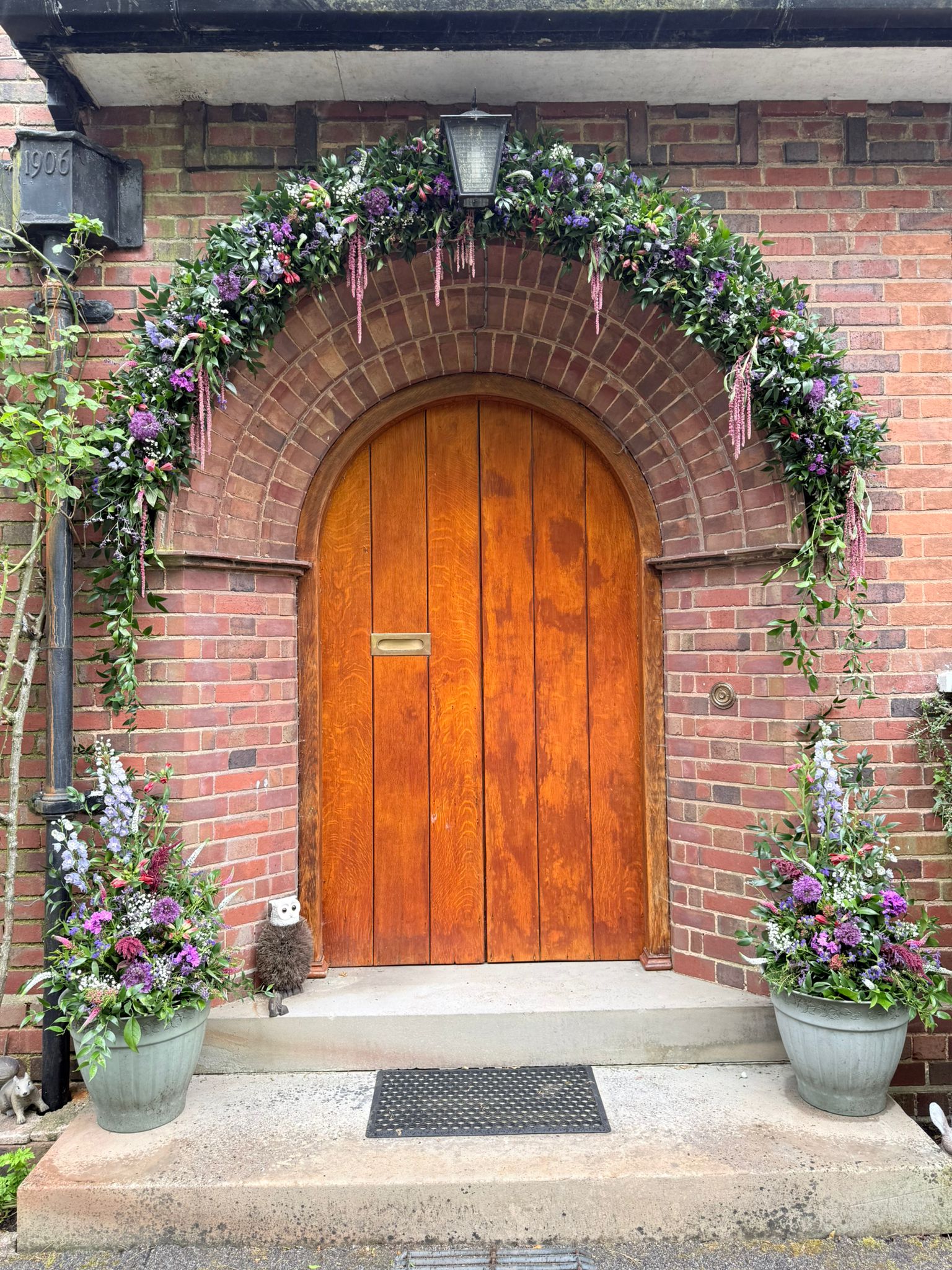 Floral arch framing a wedding doorway at a celebration planned by E&M