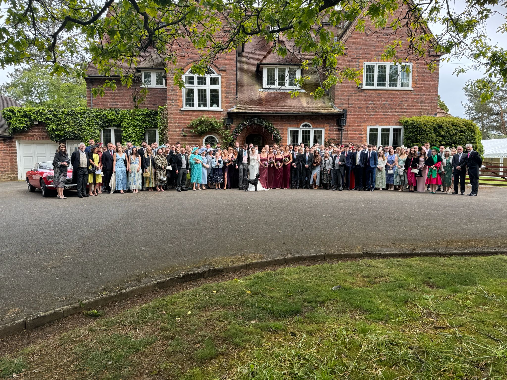 Jules and Matt with their wedding guests outside the house