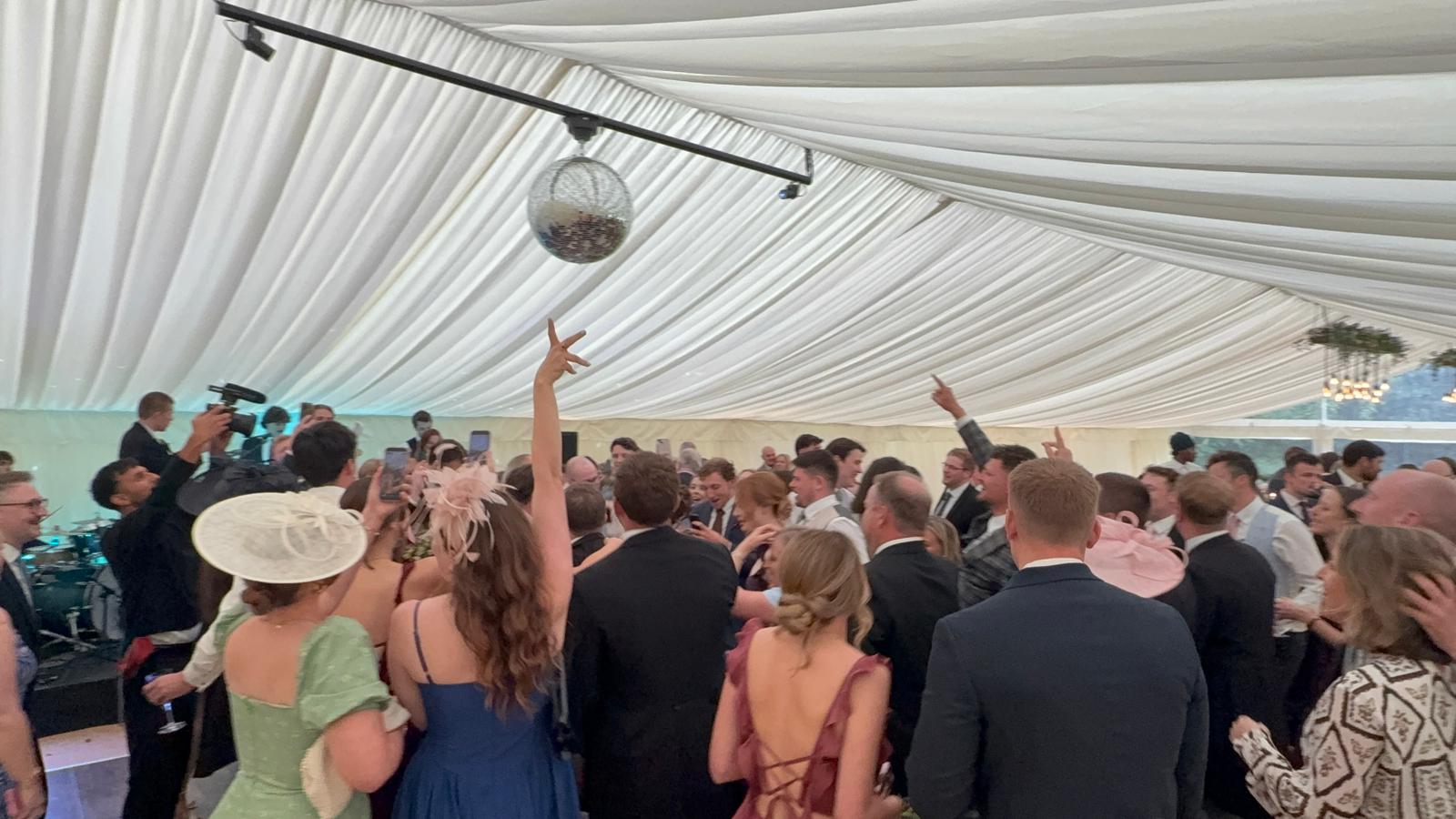 Guests filling the dance floor in a wedding marquee
